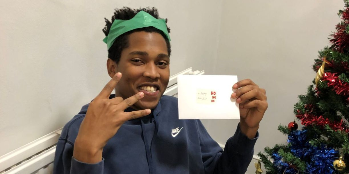 Man smiling holding a Christmas card.