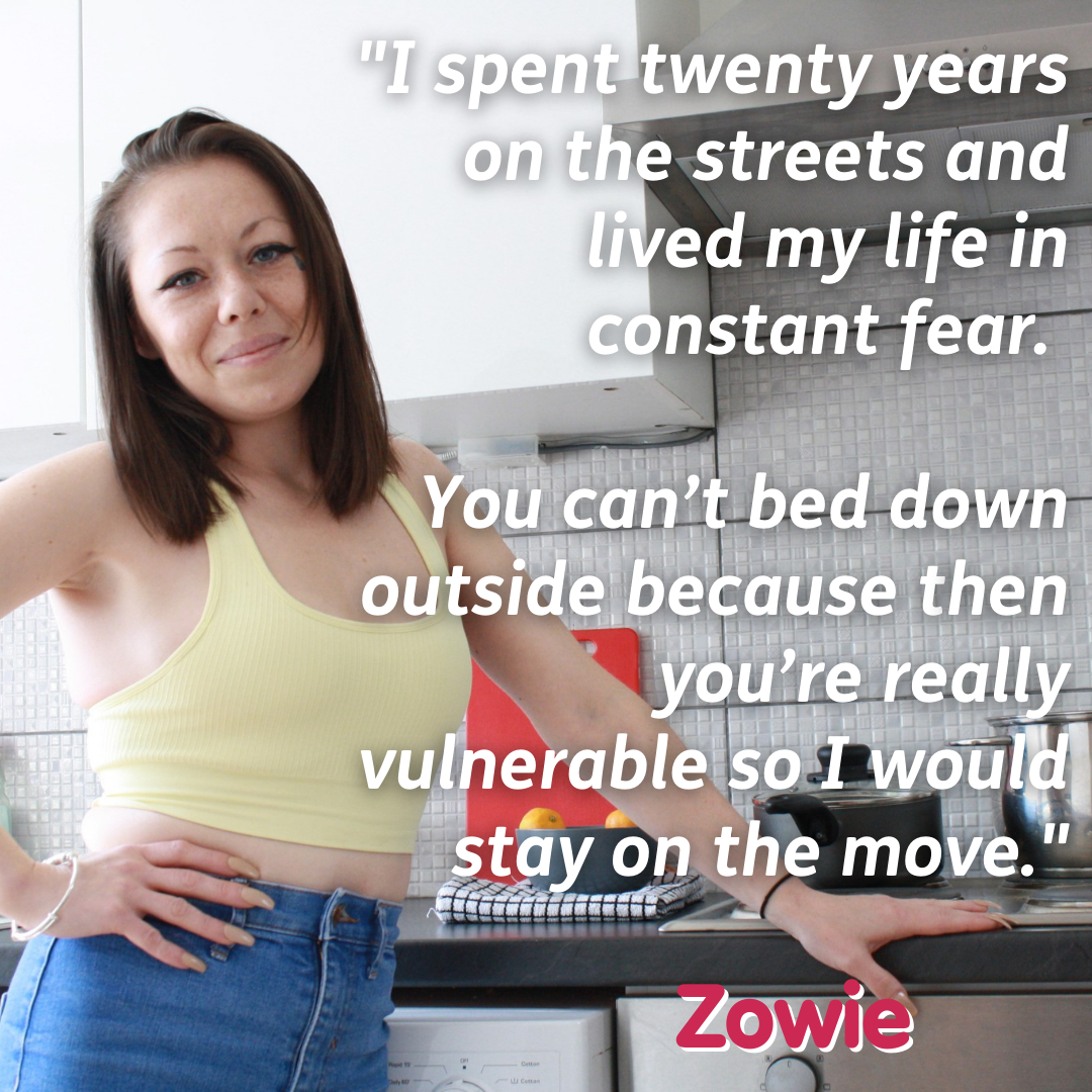 Woman in her kitchen with text "I spent twenty years on the streets and lived my life in constant fear. You can't bed down outside because you're really vulnerable so I would stay on the move. - Zowie"