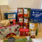Image of a. grocery shop hall with mince pies, spaghetti, tea bags, rice, oats and tinned fruit/veg.
